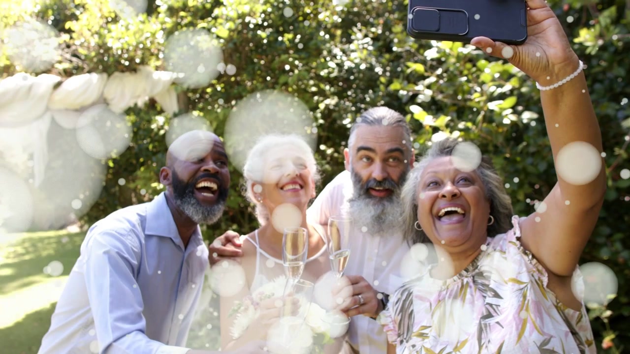 Bokeh clearing woman raising phone and group leaning in taking event selfie with flutes and bouquet