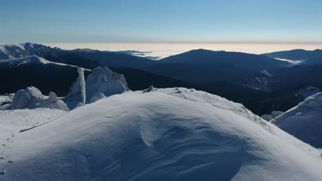 Cinematic-drone-shot-during-winter-in-Ciucas-mountains-of-Romania-with-amazing-sunny-clouds-in-the-background