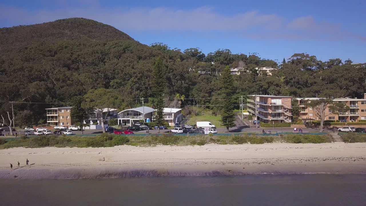hermoso panorama aéreo sobre la playa costera con casas o propiedades comunitarias frente al mar en un pequeño pueblo de sydney