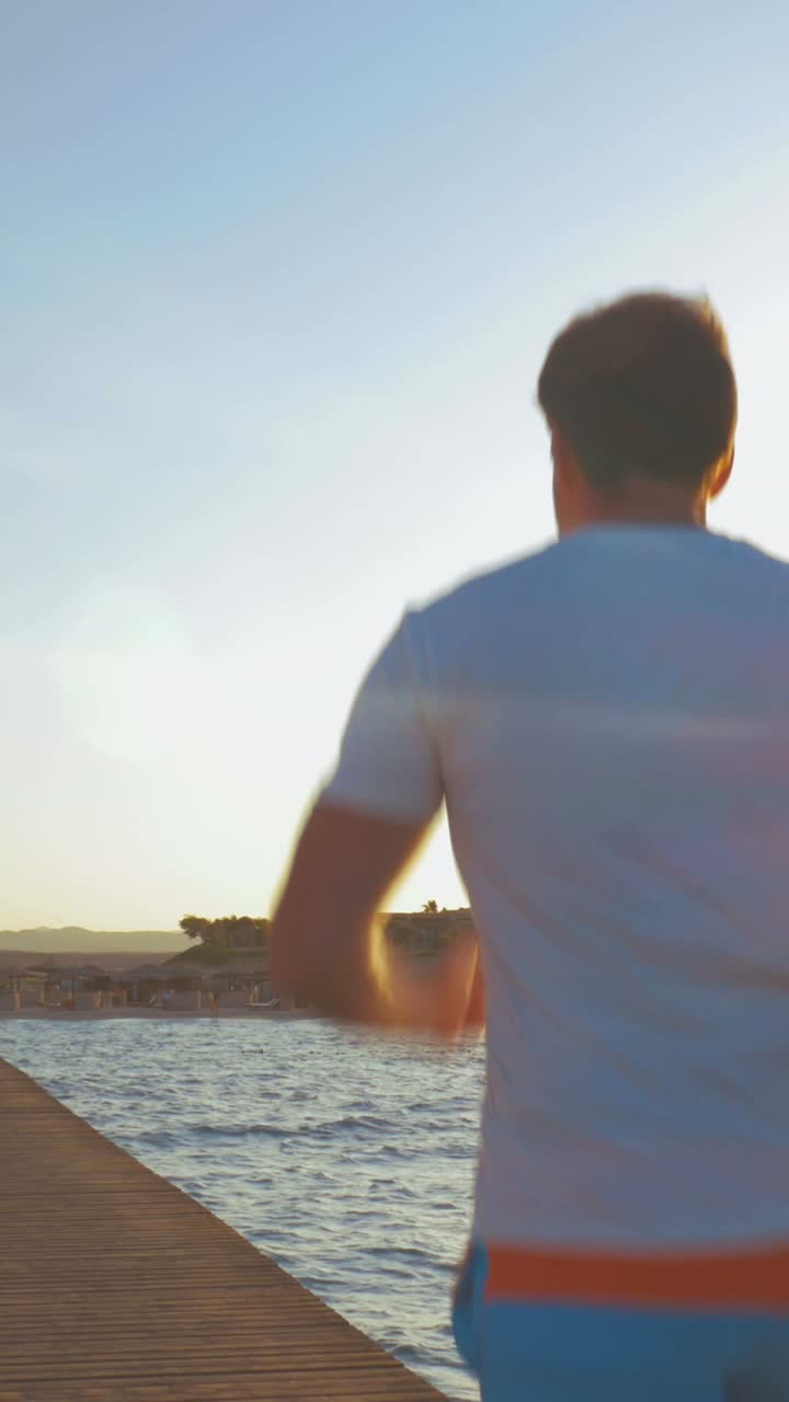 Man walking on a pier at sunset