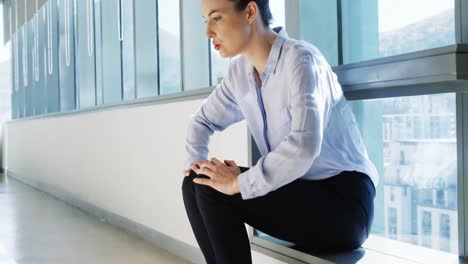 Tense-female-business-executive-sitting-with-hand-on-forehead