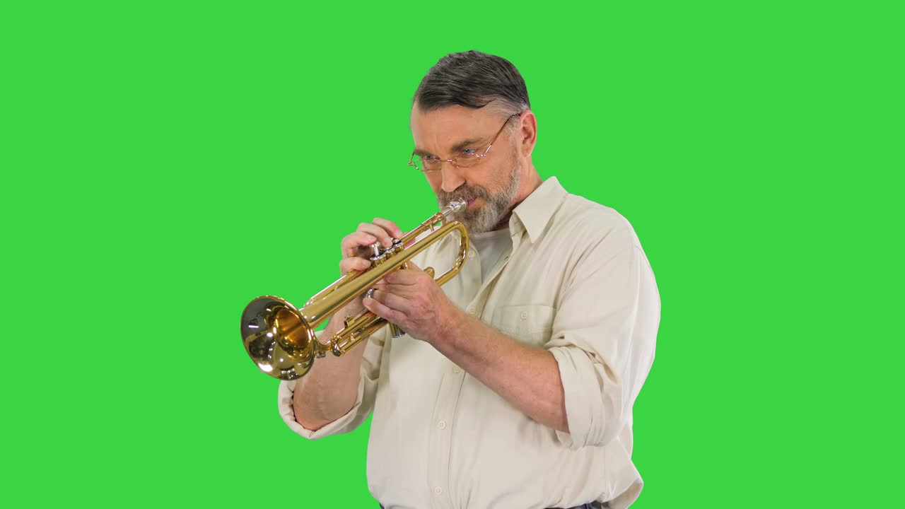 Senior musician playing a trumpet on a Green Screen, Chroma Key