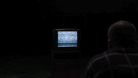 man watching a television with static