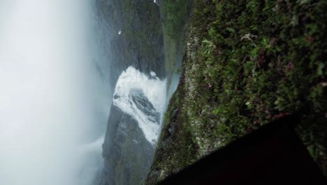 revealing powerful husedalen waterfall from inside tent, norway. vertical video