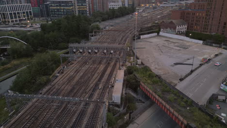 Establishing-Drone-Shot-of-Leeds-City-Centre-and-Train-Line-with-End-of-Freight-Train-at-Sunrise