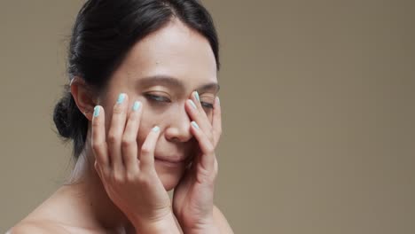 Feliz-Mujer-Asiática-Con-Cabello-Oscuro-Sobre-Fondo-Beige-Con-Espacio-Para-Copiar,-Cámara-Lenta