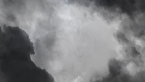 a thunderstorm with a flash of lightning within a gray cumulus cloud