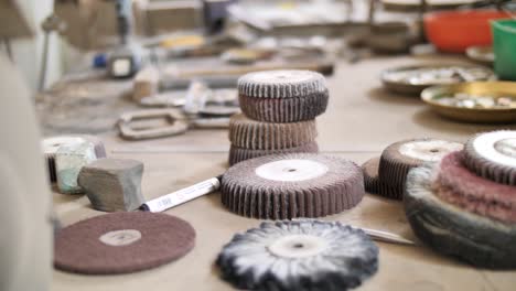 many polishing tips and small tools on table inside craftsman workshop