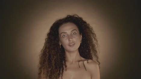 woman with gold makeup and curly hair