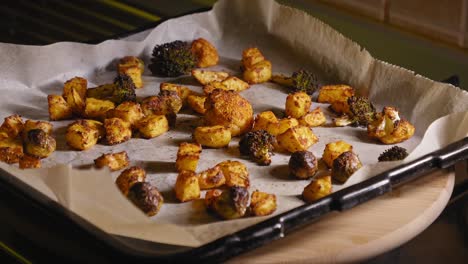 Person-is-Placing-Roasted-Vegetables-on-Baking-Sheet-on-a-Kitchen-Counter