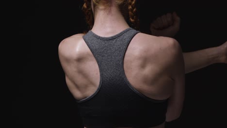 Close-Up-Studio-Shot-Showing-Back-Of-Mature-Woman-Wearing-Gym-Fitness-Clothing-Doing-Stretching-Exercises