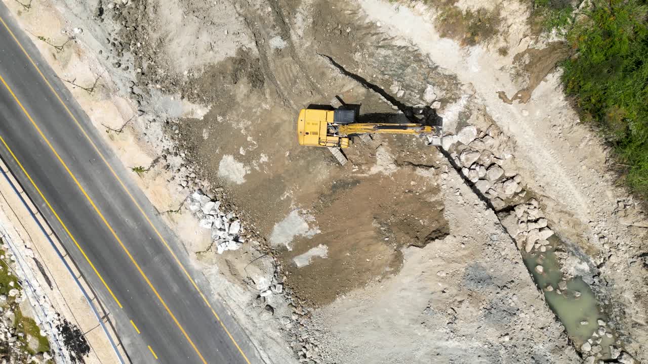 excavadora trabajando cerca de la carretera principal limpiando escombros y suciedad