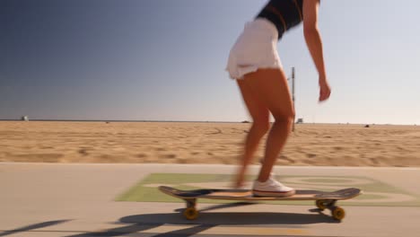 niña en longboard bailando y haciendo trucos bajo el sol en skatepark
