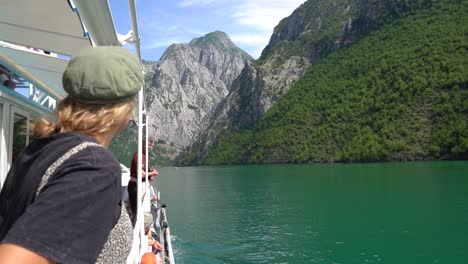 young female tourist sightseeing onboard a ferry on the stunning komani lake in northern albania, europe