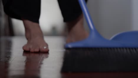 cleaning floor with sweeping broom stick and scoop