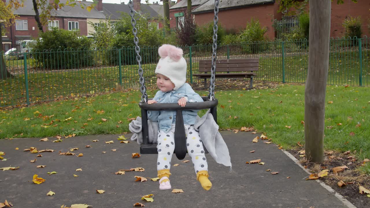 놀이터 그네를 가지고 노는 신발 하나 없는 귀여운 아이