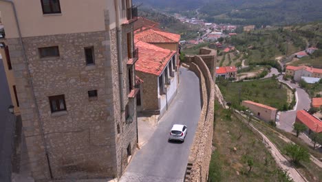 cars travel along narrow cobblestone streets in the beautiful castle fort town of morella spain