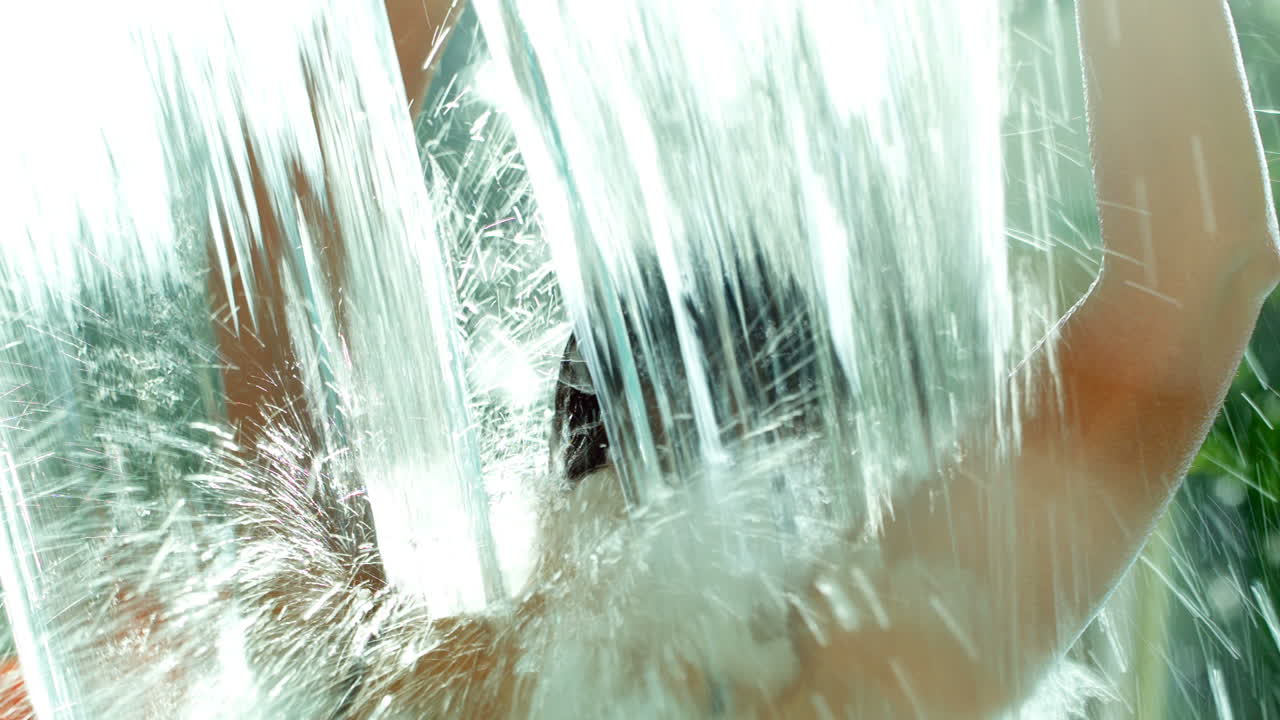 강한 샤워 하 에서 수영장 에 있는 여자 의 뒷면