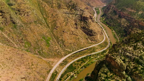 rocky hills of amazing mountains in colorado, usa. river flowing at the foot of mountain and roads passing along the river from aerial view.