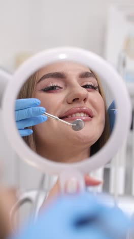 dental hygiene session elegantly showcasing patient reflection in beautifully crafted circular mirror. vertical video.