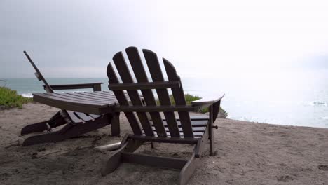 two empty wooden chairs and table by the beach