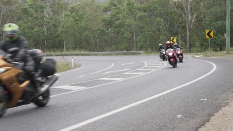 Grupo-De-Motociclistas-Recorren-Una-Esquina-De-Betún-Y-Pasan-La-Cámara