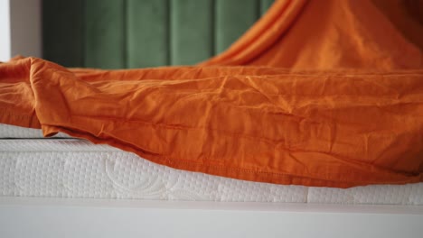 orange blanket on white mattress