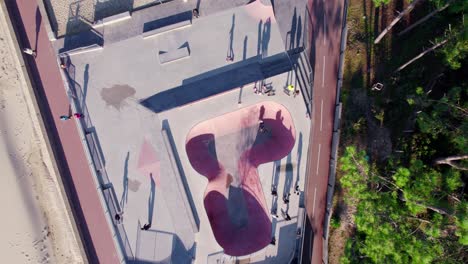 ojo de pájaro aéreo dando vueltas sobre el skatepark de carril con gente irreconocible