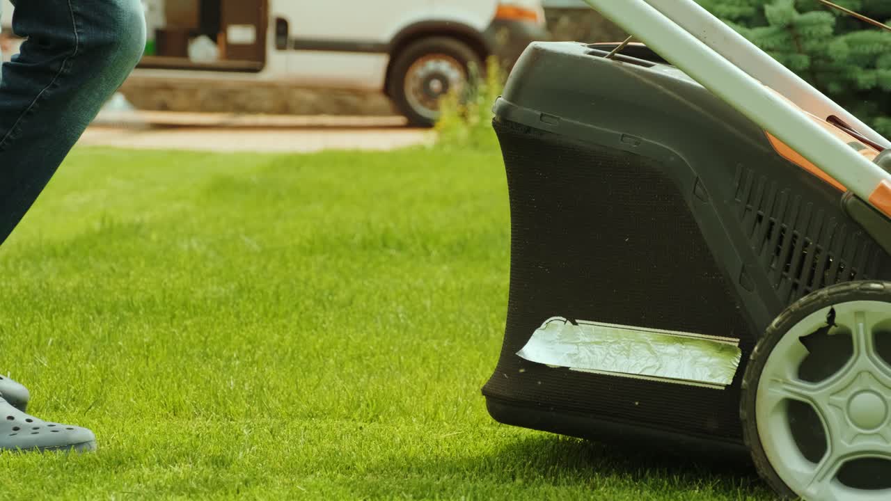 잔디를 는 잔디 기. 정원 활동. 빛 정원에서 가솔린 구동 잔디기와 함께 잔디을 는. 정원에서 잔디 자르기 기계와 함께 일하는 정원사. 잔디자리 기