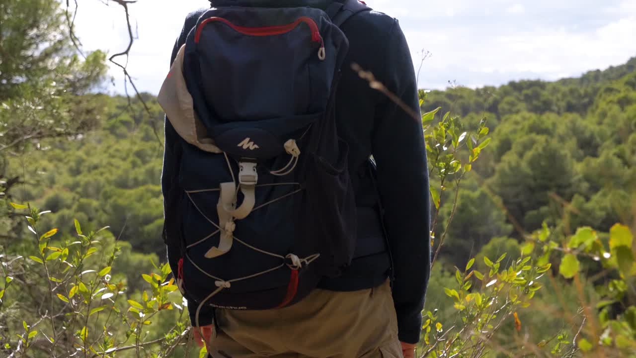 медленно поднимающийся снимок туриста, стоящего на смотровой площадке, восхищаясь видами леса