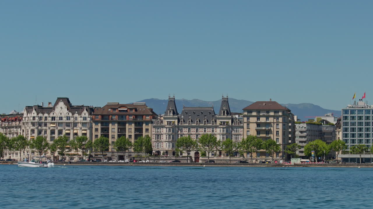 Peaceful morning in Geneva with the iconic Jet d’Eau rising from the lake, calm waters reflecting the clear sky, and the city slowly coming to life in the morning light.