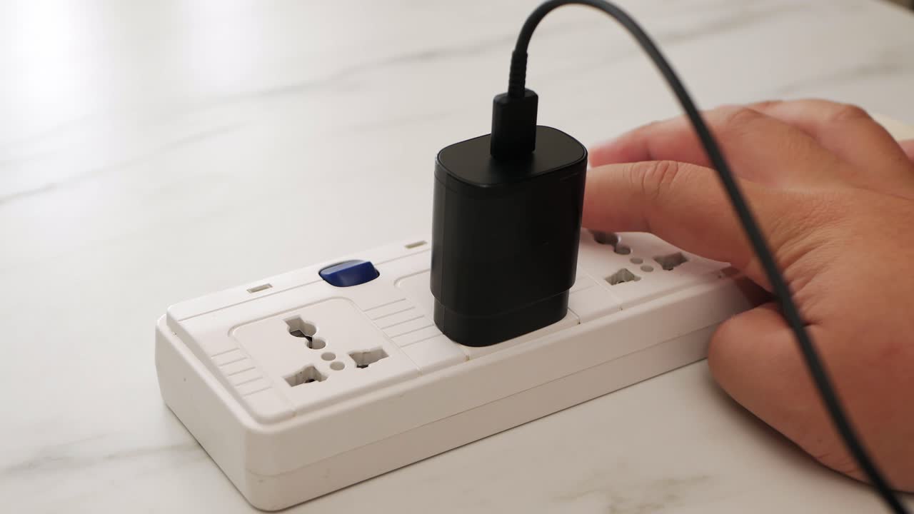 남자 손으로 전화 어댑터 배터리 충전기를 연결하고 휴대 전화 사용을 위해 스위치를 켭니다.