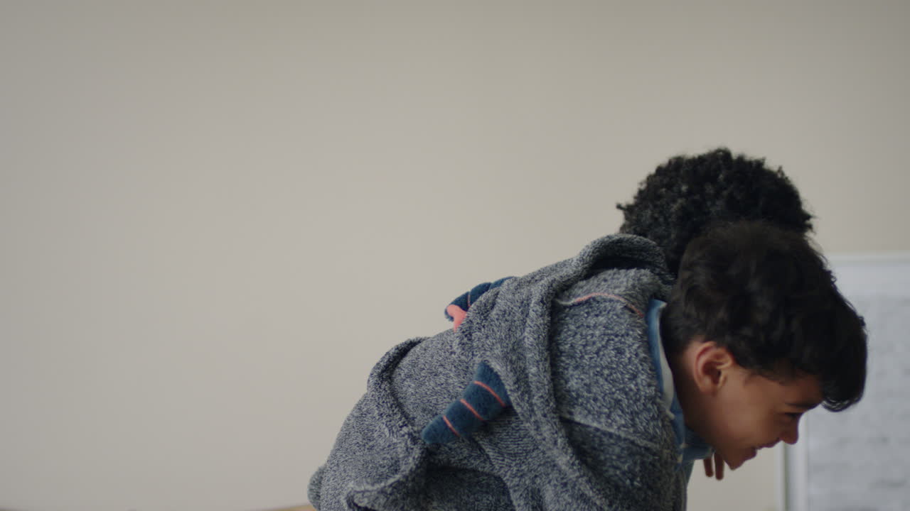 행복한 작은 소년은 아버지의 등으로 뛰어들어 아버지와 함께 놀고 집에서 아들과 함께 장난스러운 게임을 즐기고 있습니다.