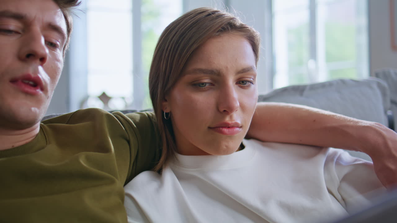 Romantic couple watching movie tablet during home weekend closeup. Hugging pair