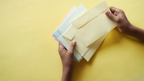 hands holding a stack of colorful envelopes