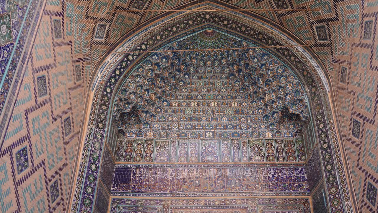 azulejos azules detallados en el arco histórico que entra en una mezquita tradicional en la plaza registan en samarcanda, uzbekistán a lo largo de la histórica ruta de la seda