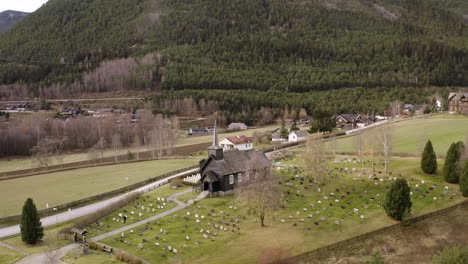 panoramic view on idyllic landscape with a wooden church in sel, norway - aerial drone shot