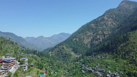 aerial view short of jibhi himachal pradesh in india. houses and trees in the mountainous area. faguli festival is one of the biggest festival in jibhi. the traditional houses here have stone roofs.