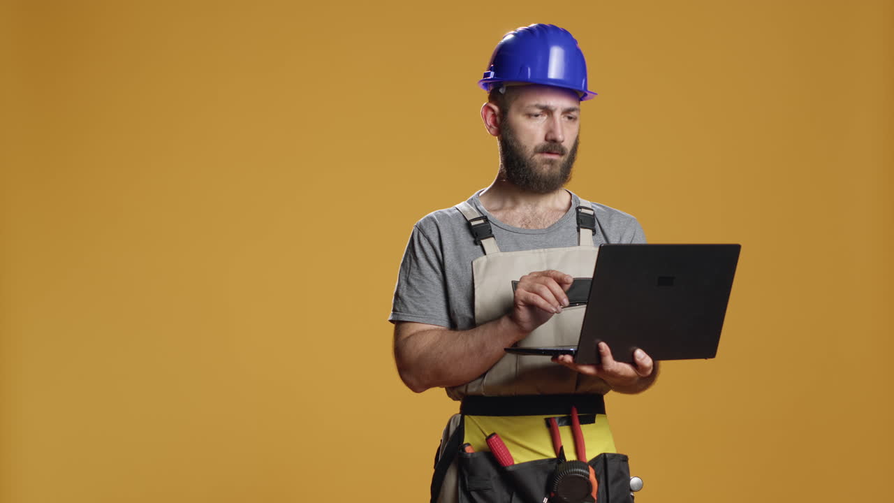 Portrait of handyman using laptop to find construction inspiration
