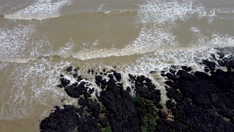 4k drone video of the sea coming into shore over rocks