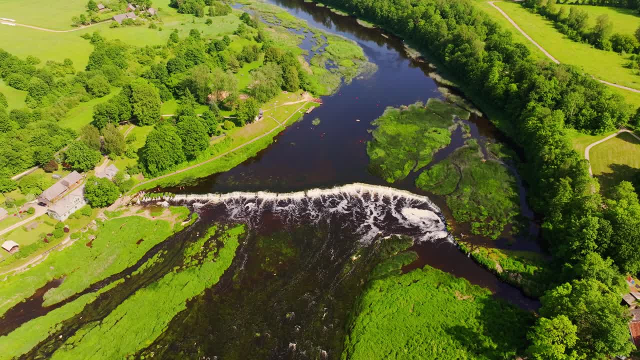 Aerial perspective captures Europe widest waterfall Venta Rapid with green banks