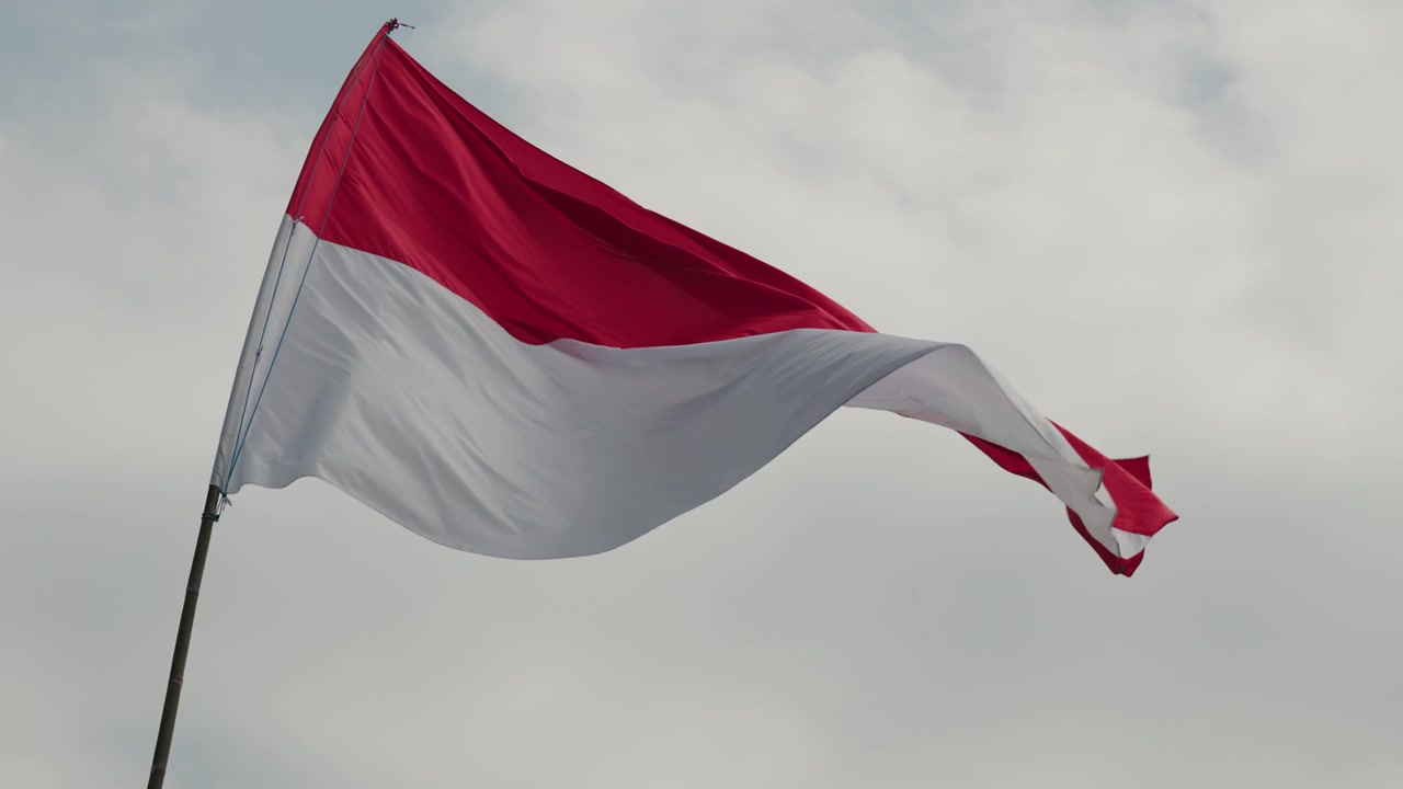 Bandiera indonesiana che sventola contro un cielo nuvoloso