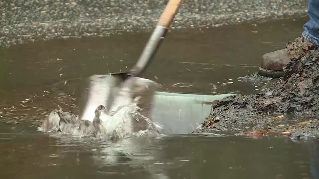 빗물을 위해 도시의 거리 배수구를 뽑습니다.