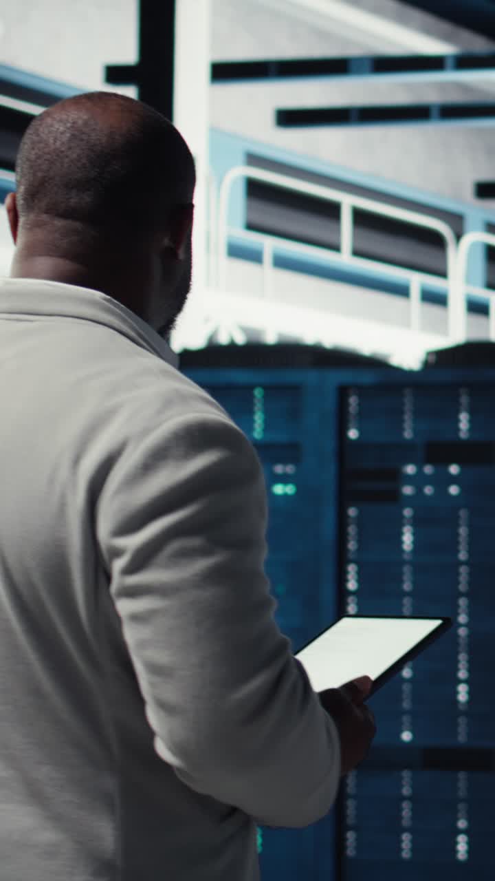 Vertikal video Systemadministrator i datacenter kontrollerer infrastrukturdiagnostik ved hjælp af tablet
