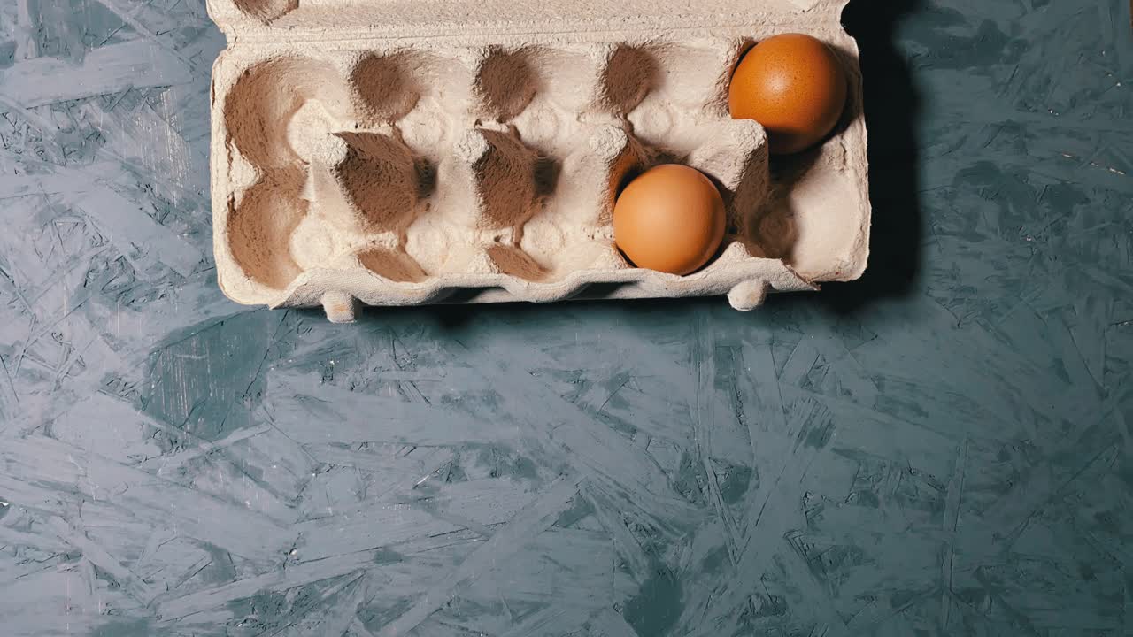 Stop Motion Of Two Organic Eggs Moving Around In An Egg Tray, overhead shot