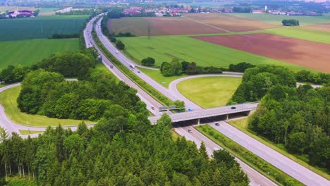 Timelapse of a droneshot next to a german Autobahn with much driving cars, smootly zoomed out from the freeway scenery