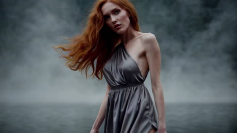 woman in a gray satin dress in a misty forest
