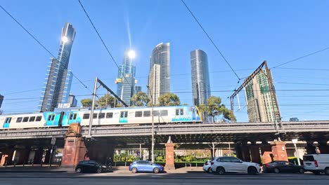 train crossing bridge with skyscrapers in background