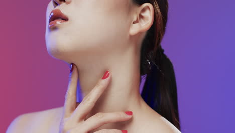 asian woman with black hair and make up touching neck, copy space, slow motion