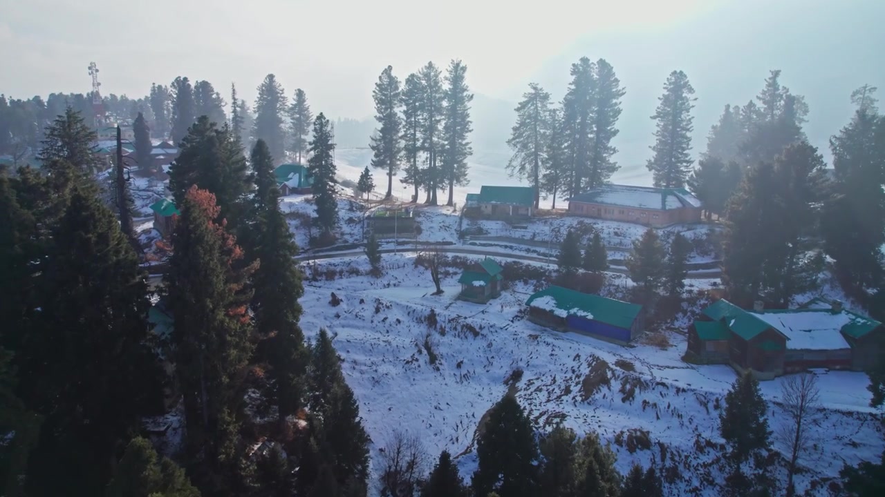Drzewa i domy w śniegu, ujęcie lotnicze z drona 4K. Gulmarg, Dżammu i Kaszmir, Indie.